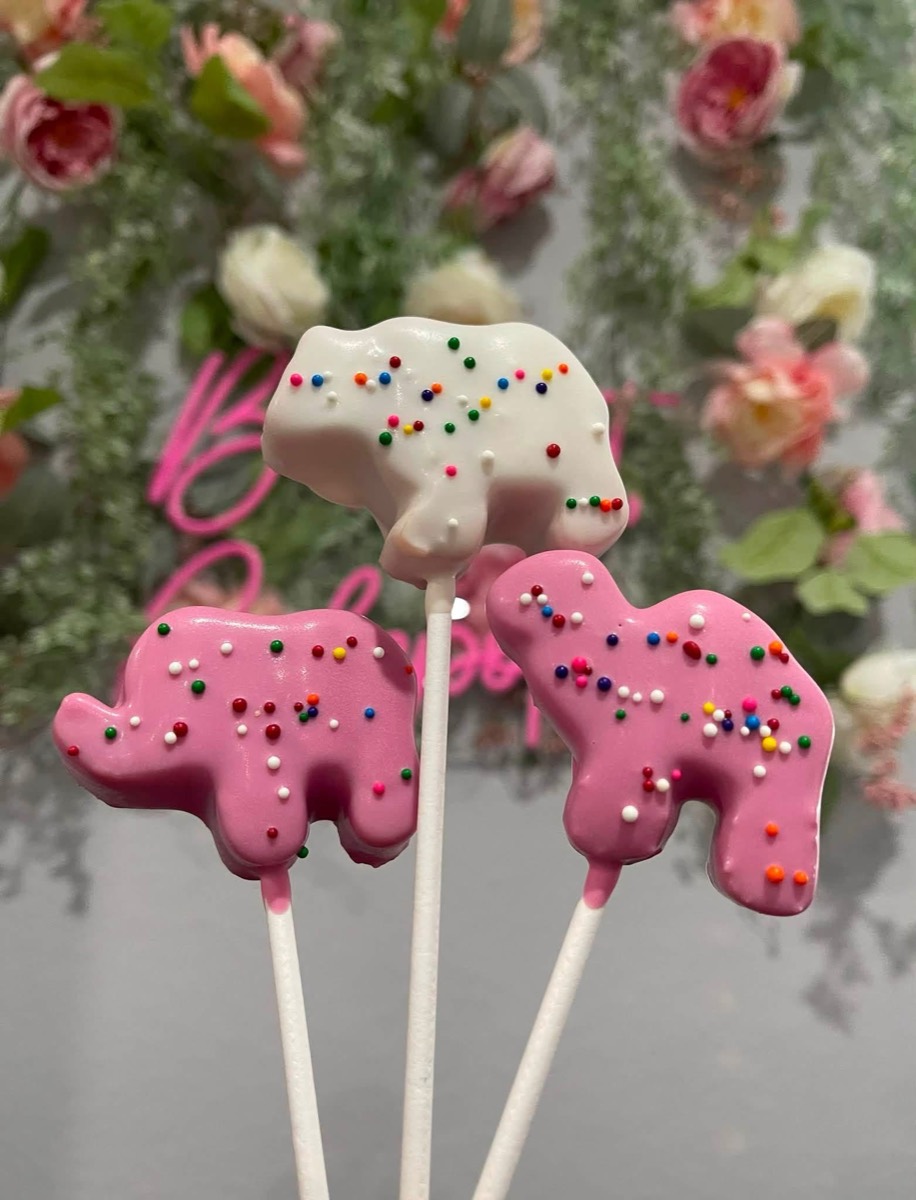 Frosted circus-animal cookie pops in pink and white with sprinkles
