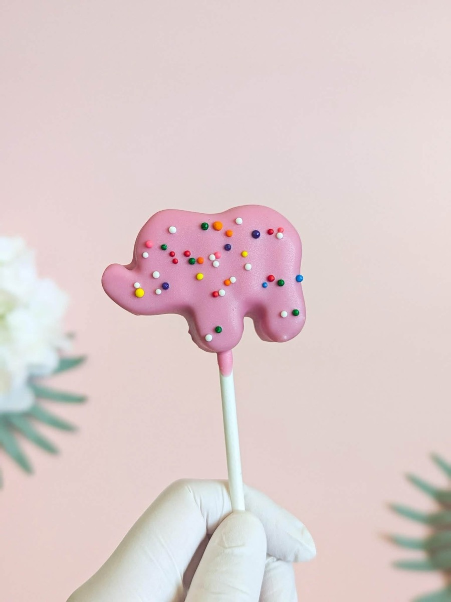 Pink elephant cake pop covered in rainbow sprinkles