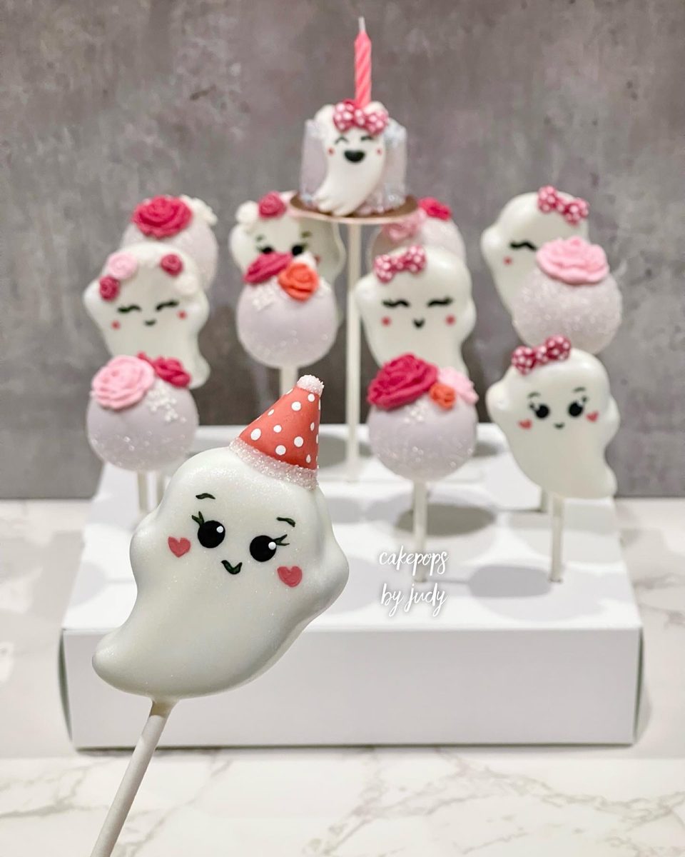 Smiling ghost cake pops with hand-piped roses and party hats