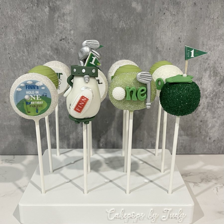 Golf-theme first birthday cake pops with clubs and a flag