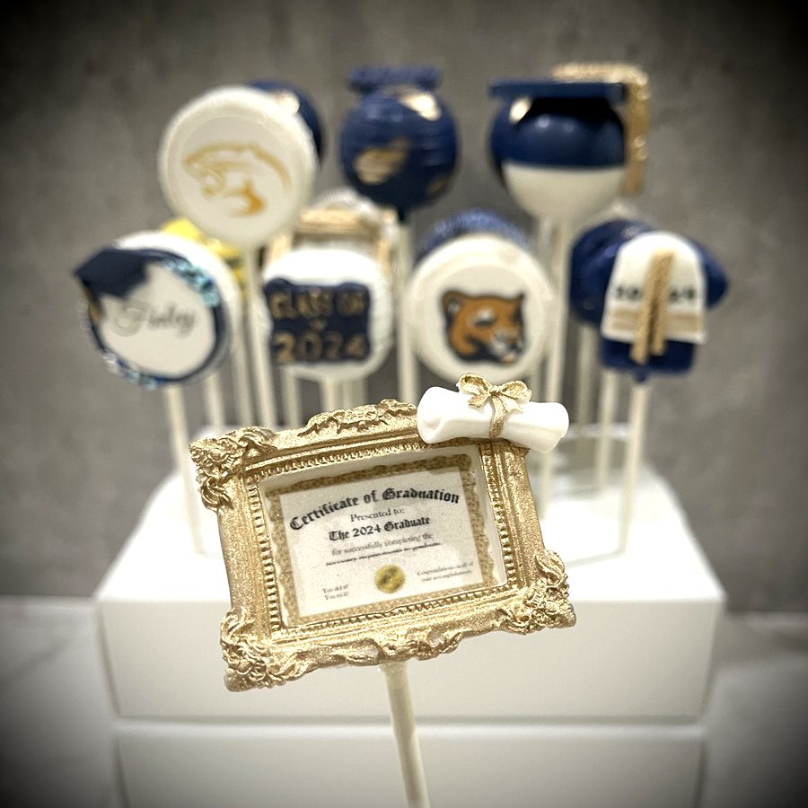 Navy and gold graduation cake pops with a Class of 2024 certificate