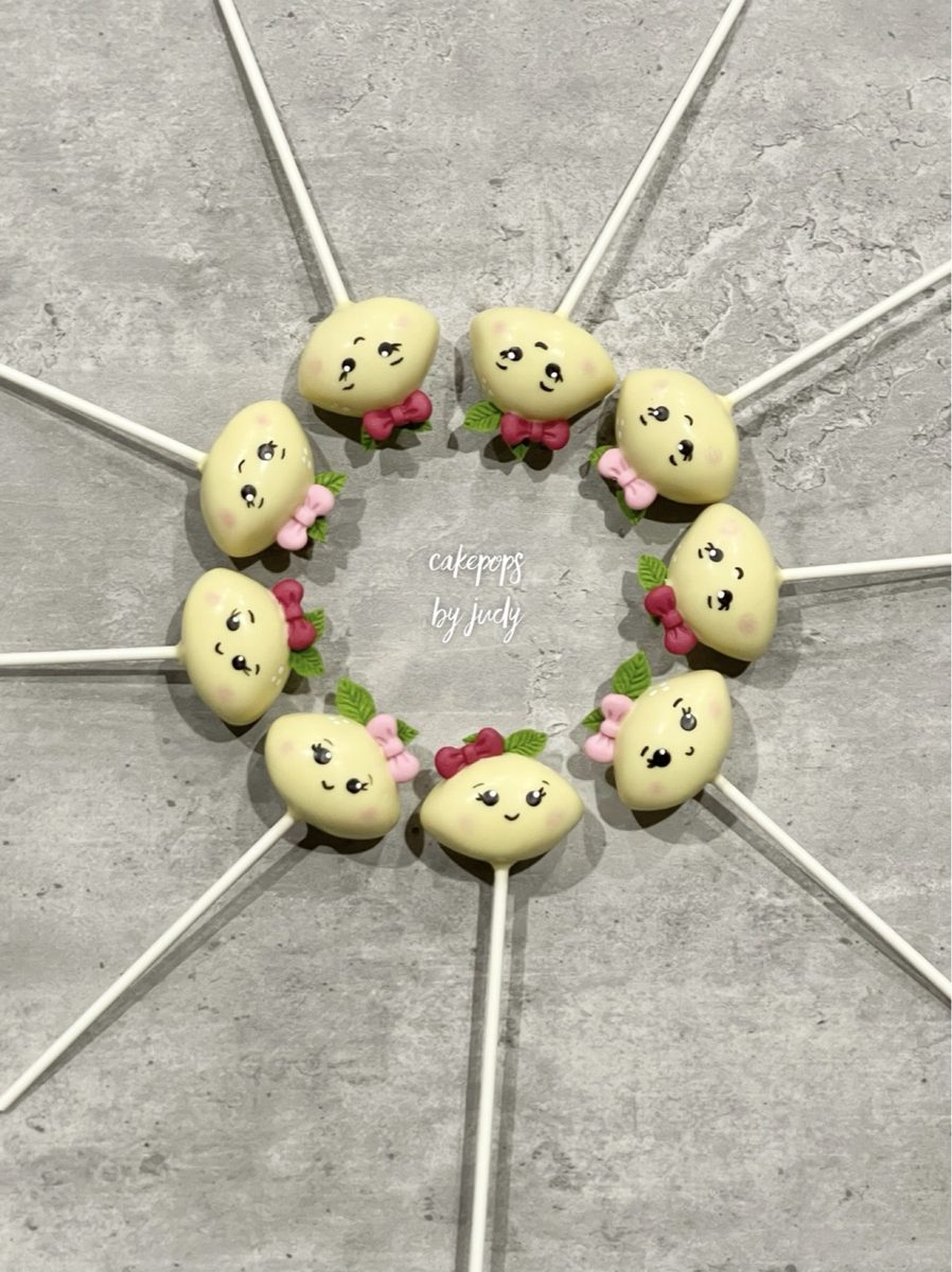 Lemon cake pops with hand-painted faces and little bows